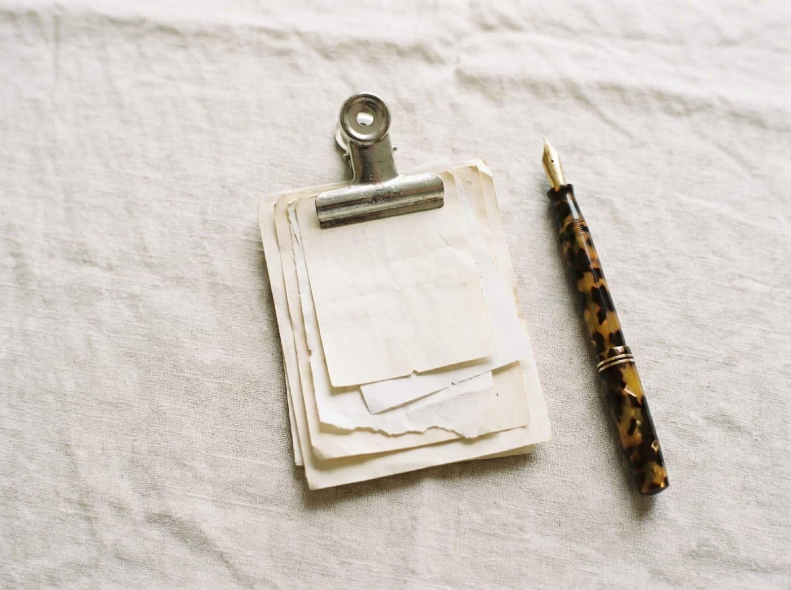 Recibos y comprobantes de papel apilados con una pinza metálica sobre una mesa clara