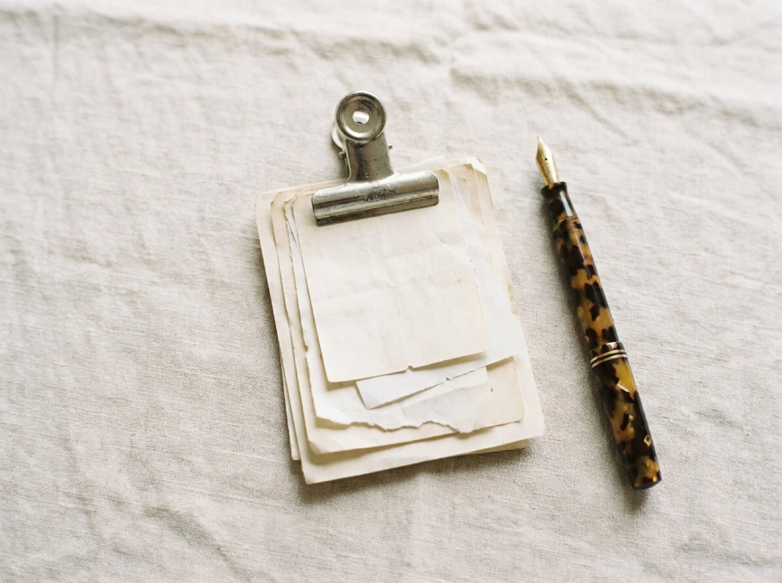 Recibos y comprobantes de papel apilados con una pinza metálica sobre una mesa clara