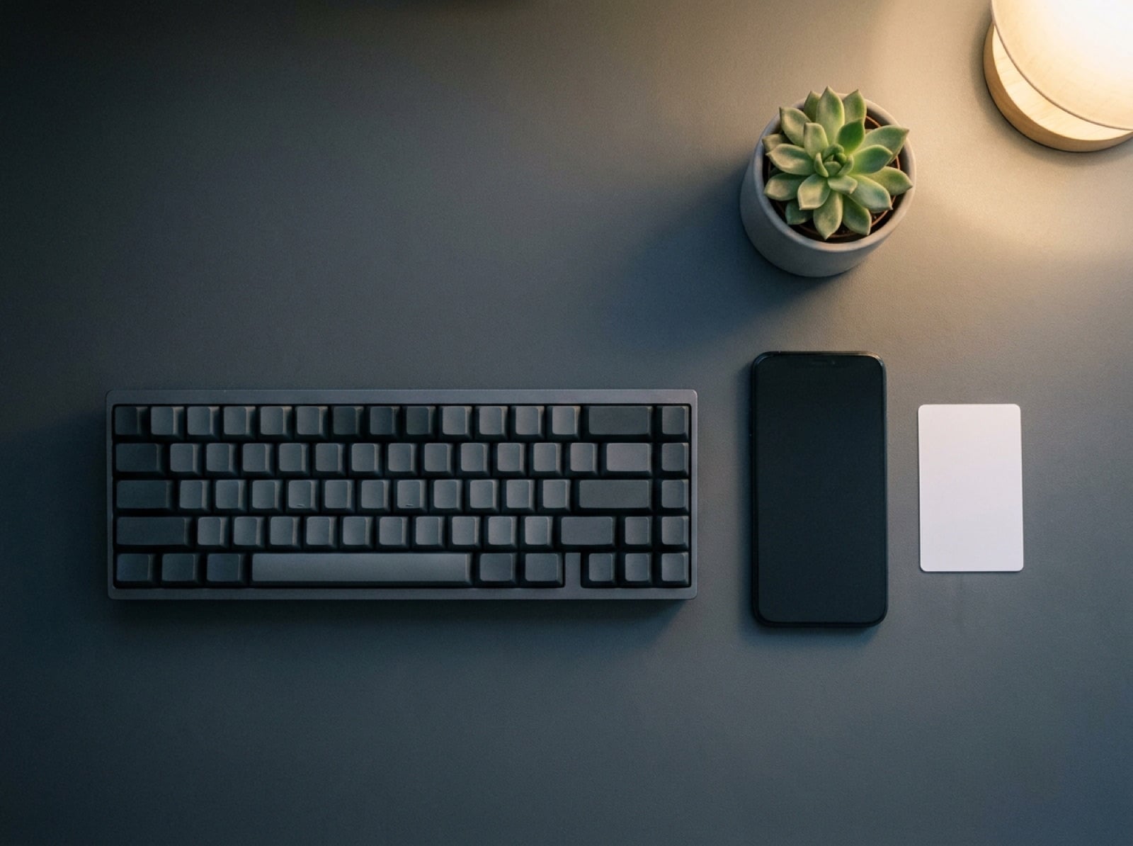 Manos ausentes: un teclado, una tarjeta de identificación boca abajo y un teléfono sobre un escritorio ordenado