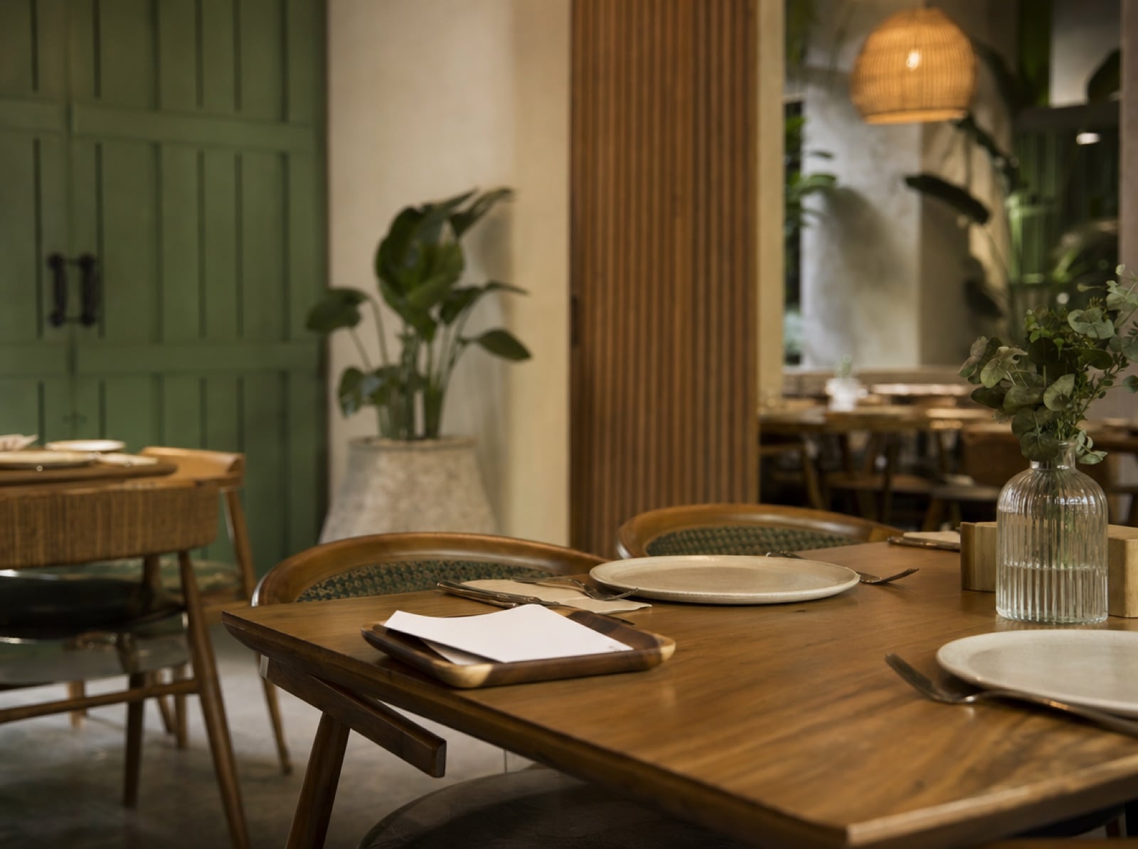 Mesa de restaurante preparada con platos vacíos y una cuenta doblada