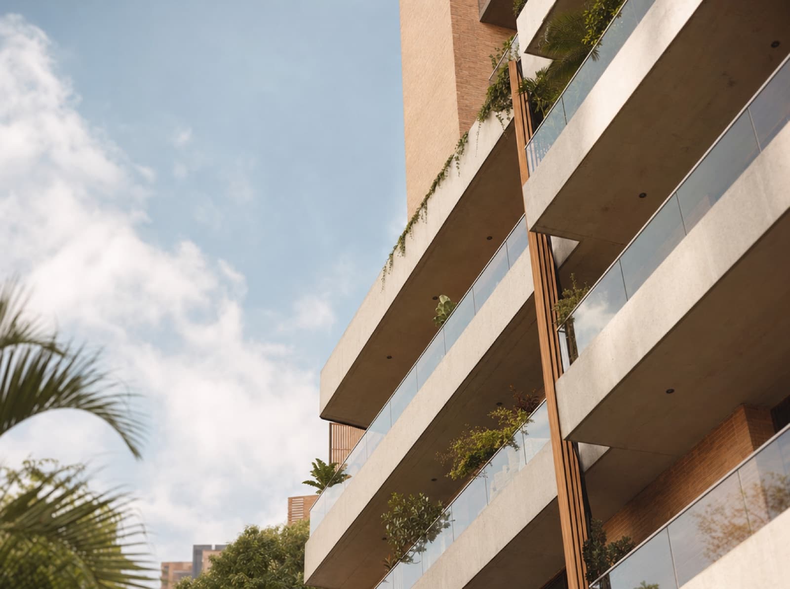 Edificio de apartamentos en Medellín visto desde abajo con balcones y plantas